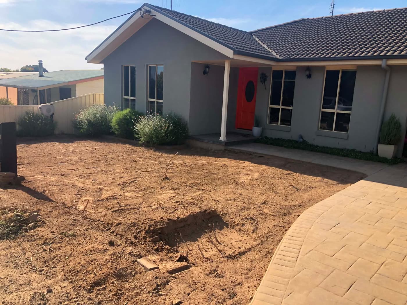 Bare dirt front yard before the new lawn
