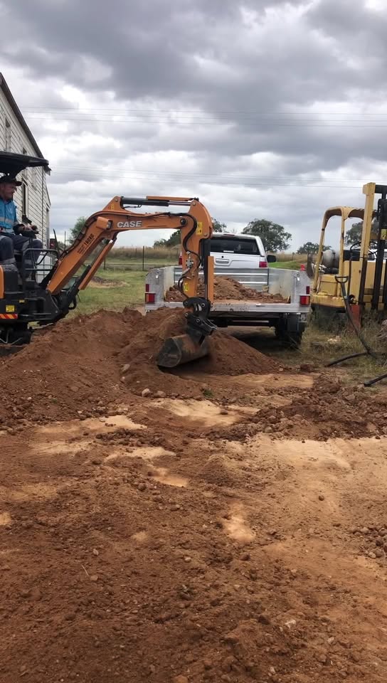 Excavator loading spoil into the tipper for removal